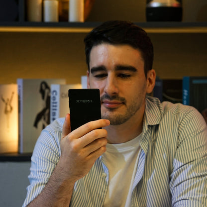 Black Xteink pocket eReader held in hand, screen facing viewer