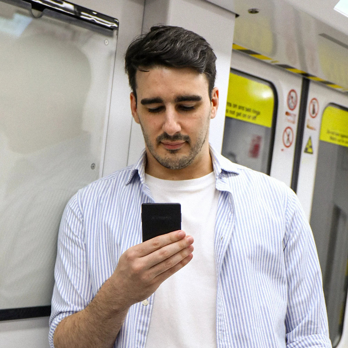 Black Xteink X3 pocket eReader held in hand, front screen visible.