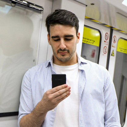 Black Xteink X3 pocket eReader held in hand, front screen visible.