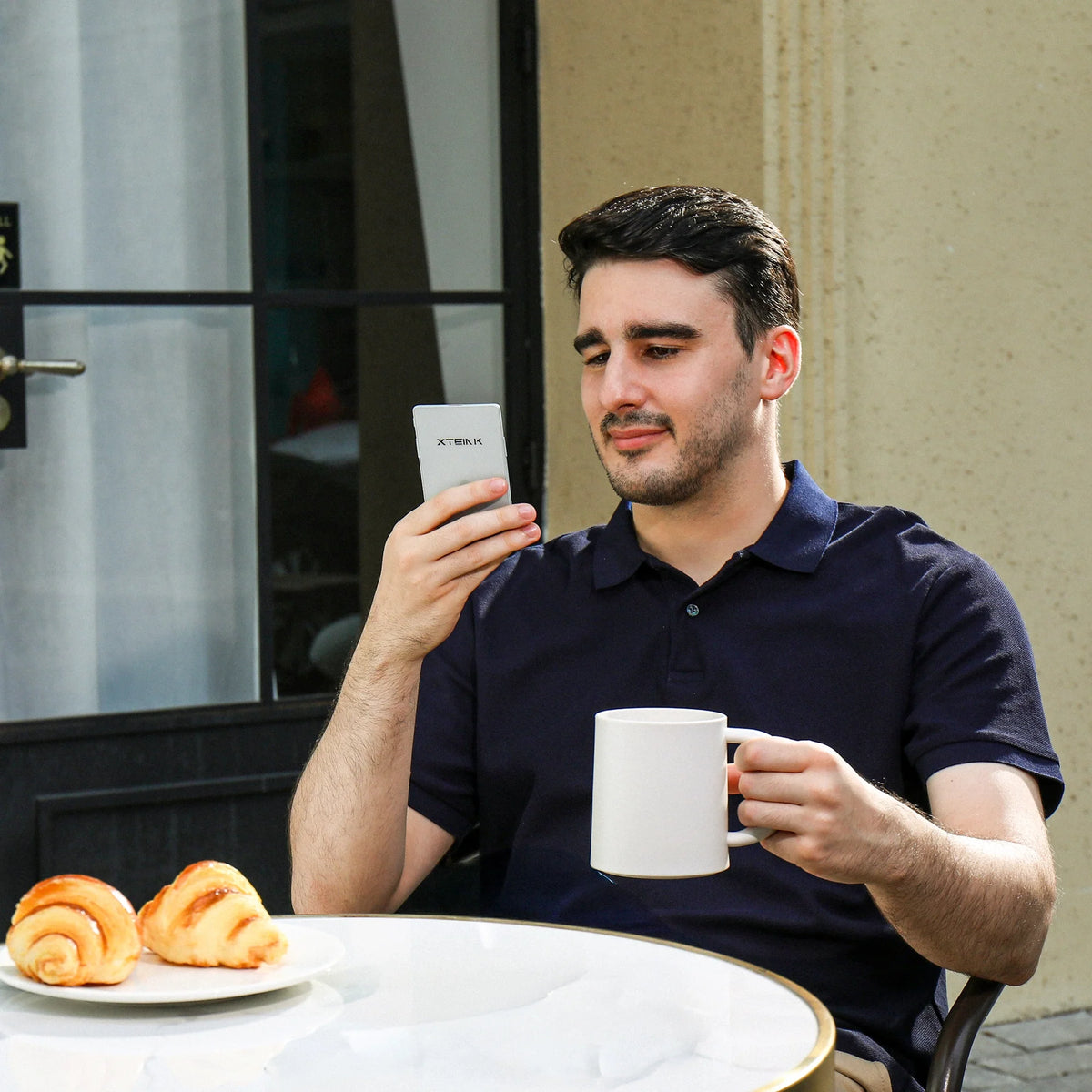 Man holding Xteink pocket eReader, dark display with text