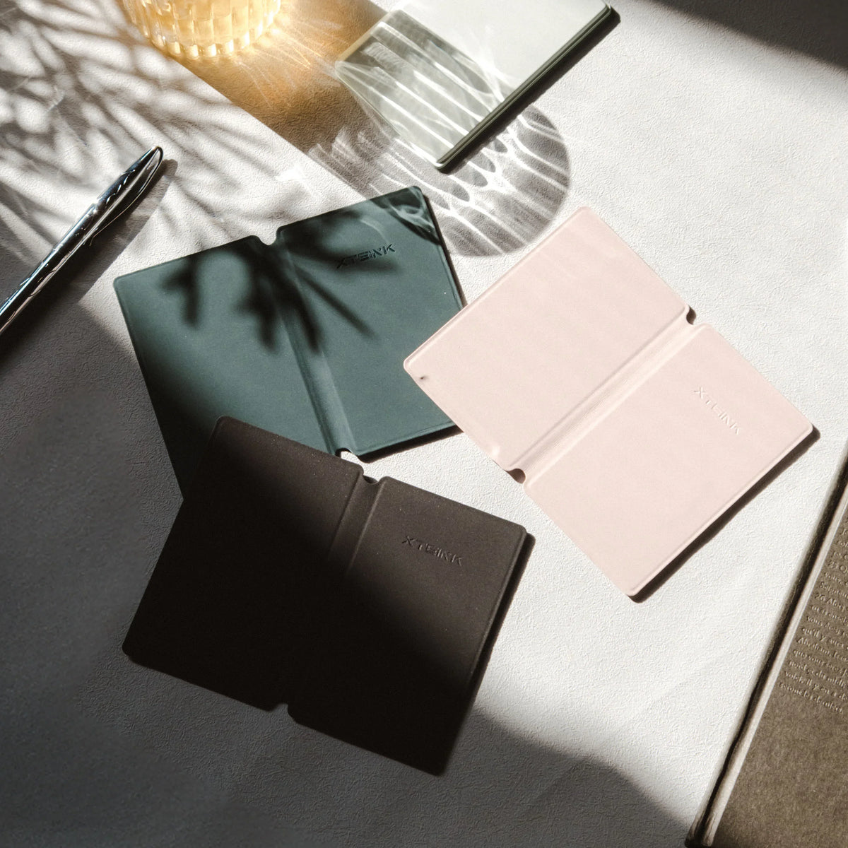 Magnetic phone cases in black, teal, and pink with white control unit nearby